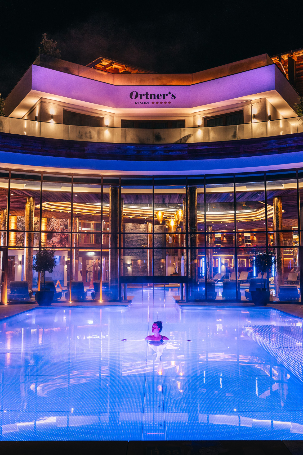 Außenansicht von Ortner's Resort in Bad Füssing mit Pool bei Nacht mit Beleuchtung